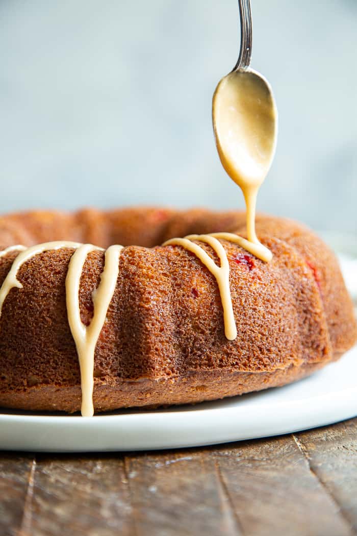 This Paleo Cranberry Orange Bundt Cake is perfectly moist  bursting with sweet orange flavor and tart juice cranberries.  A cinnamon swirl plus sweet maple glaze make this bundt cake a holiday showstopper!  It’s gluten-free, grain free, refined sugar free and has a dairy-free option. 