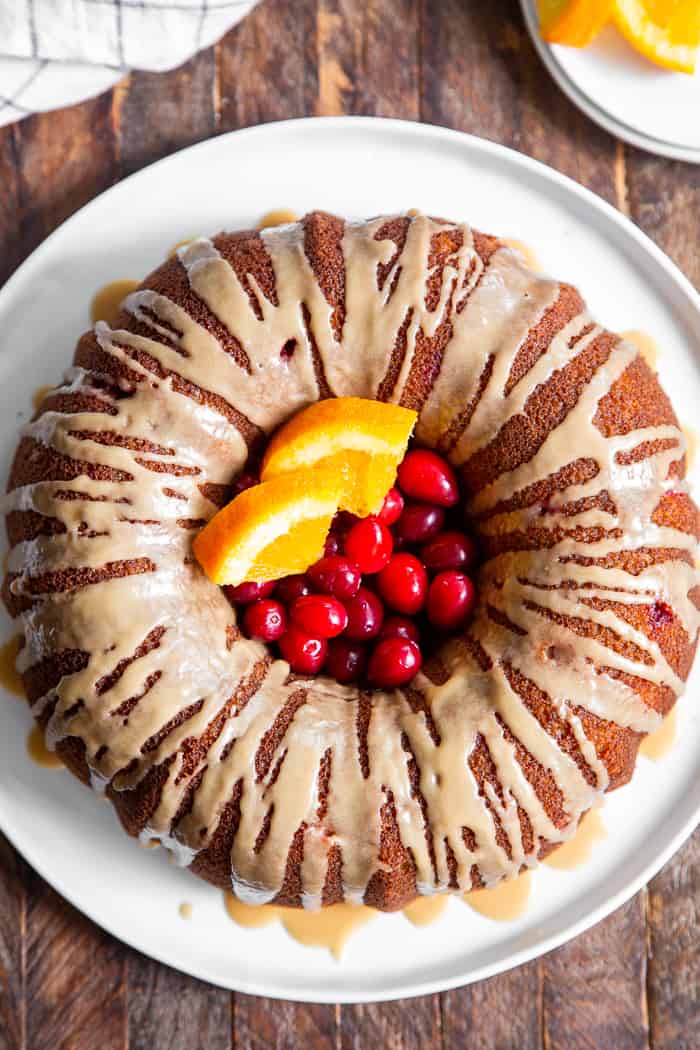 This Paleo Cranberry Orange Bundt Cake is perfectly moist  bursting with sweet orange flavor and tart juice cranberries.  A cinnamon swirl plus sweet maple glaze make this bundt cake a holiday showstopper!  It’s gluten-free, grain free, refined sugar free and has a dairy-free option. 