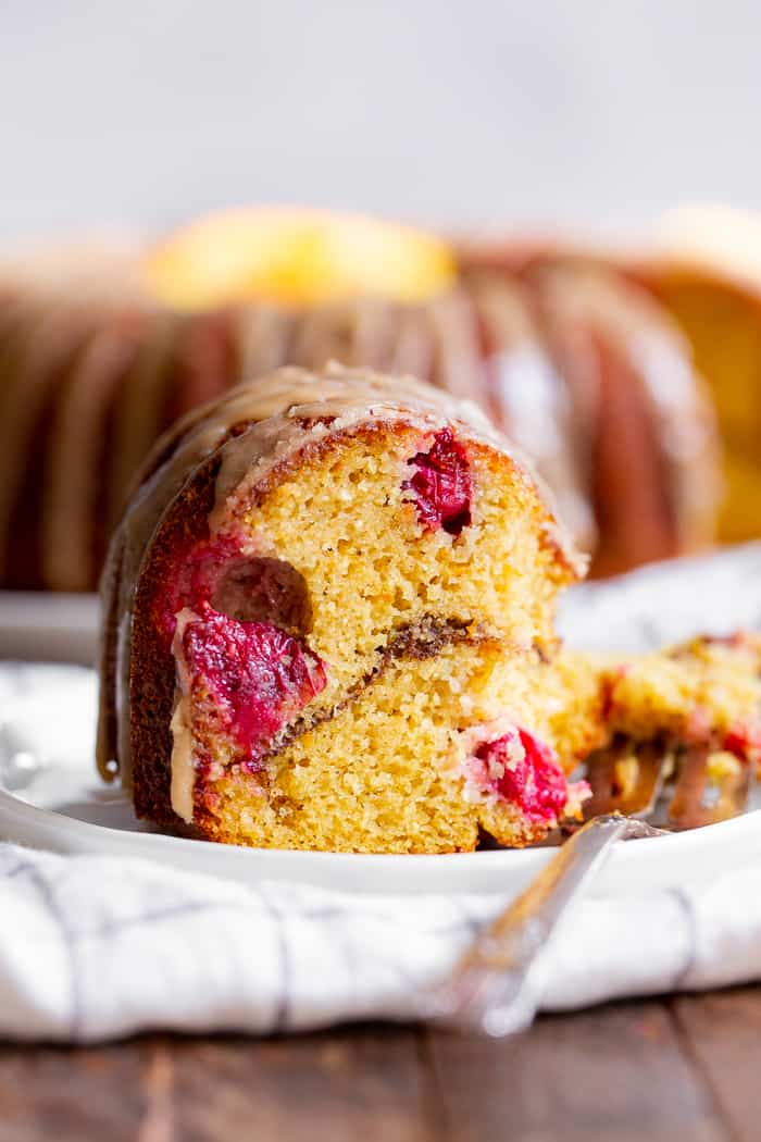 This Paleo Cranberry Orange Bundt Cake is perfectly moist  bursting with sweet orange flavor and tart juice cranberries.  A cinnamon swirl plus sweet maple glaze make this bundt cake a holiday showstopper!  It’s gluten-free, grain free, refined sugar free and has a dairy-free option. 