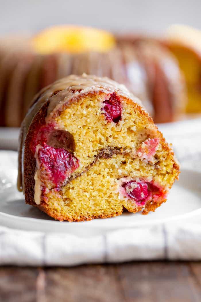 This Paleo Cranberry Orange Bundt Cake is perfectly moist  bursting with sweet orange flavor and tart juice cranberries.  A cinnamon swirl plus sweet maple glaze make this bundt cake a holiday showstopper!  It’s gluten-free, grain free, refined sugar free and has a dairy-free option. 