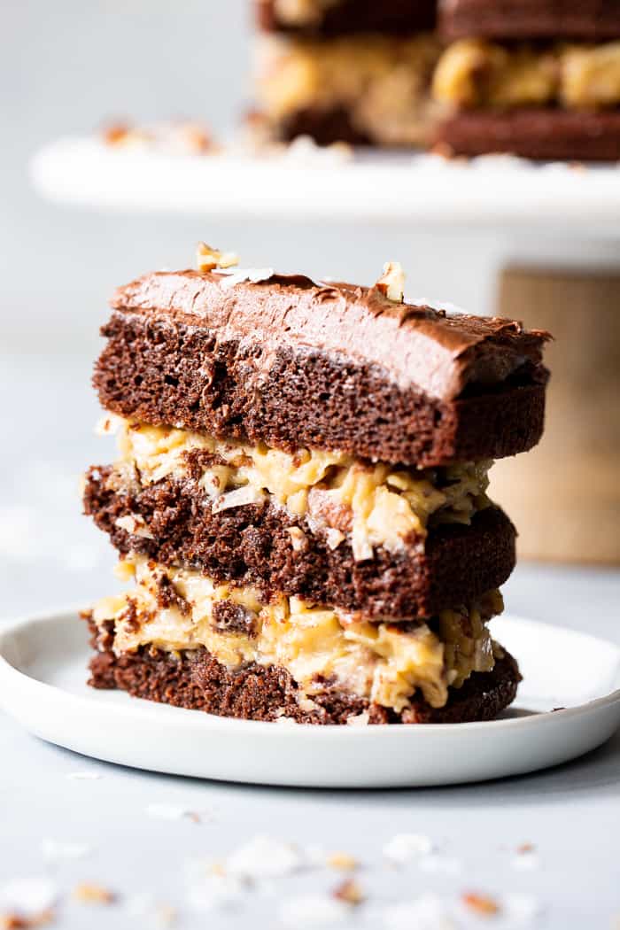 This rich Paleo German Chocolate Cake has a classic coconut pecan filling between tender grain free chocolate cake layers, and is topped with a dairy-free, refined sugar free chocolate frosting.  A showstopper for any gathering, this healthy German Chocolate Cake will become a family favorite!