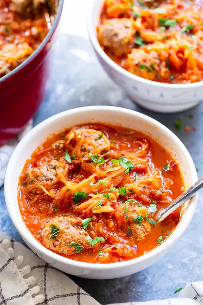 This healthy spaghetti and meatball soup uses spaghetti squash instead of pasta to make it lower in carbs, gluten-free, paleo and Whole30 compliant!  This savory, cozy soup is the perfect answer to your spaghetti and meatball cravings! 
