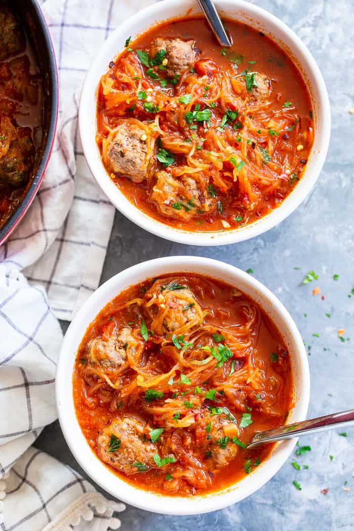 This healthy spaghetti and meatball soup uses spaghetti squash instead of pasta to make it lower in carbs, gluten-free, paleo and Whole30 compliant!  This savory, cozy soup is the perfect answer to your spaghetti and meatball cravings! 