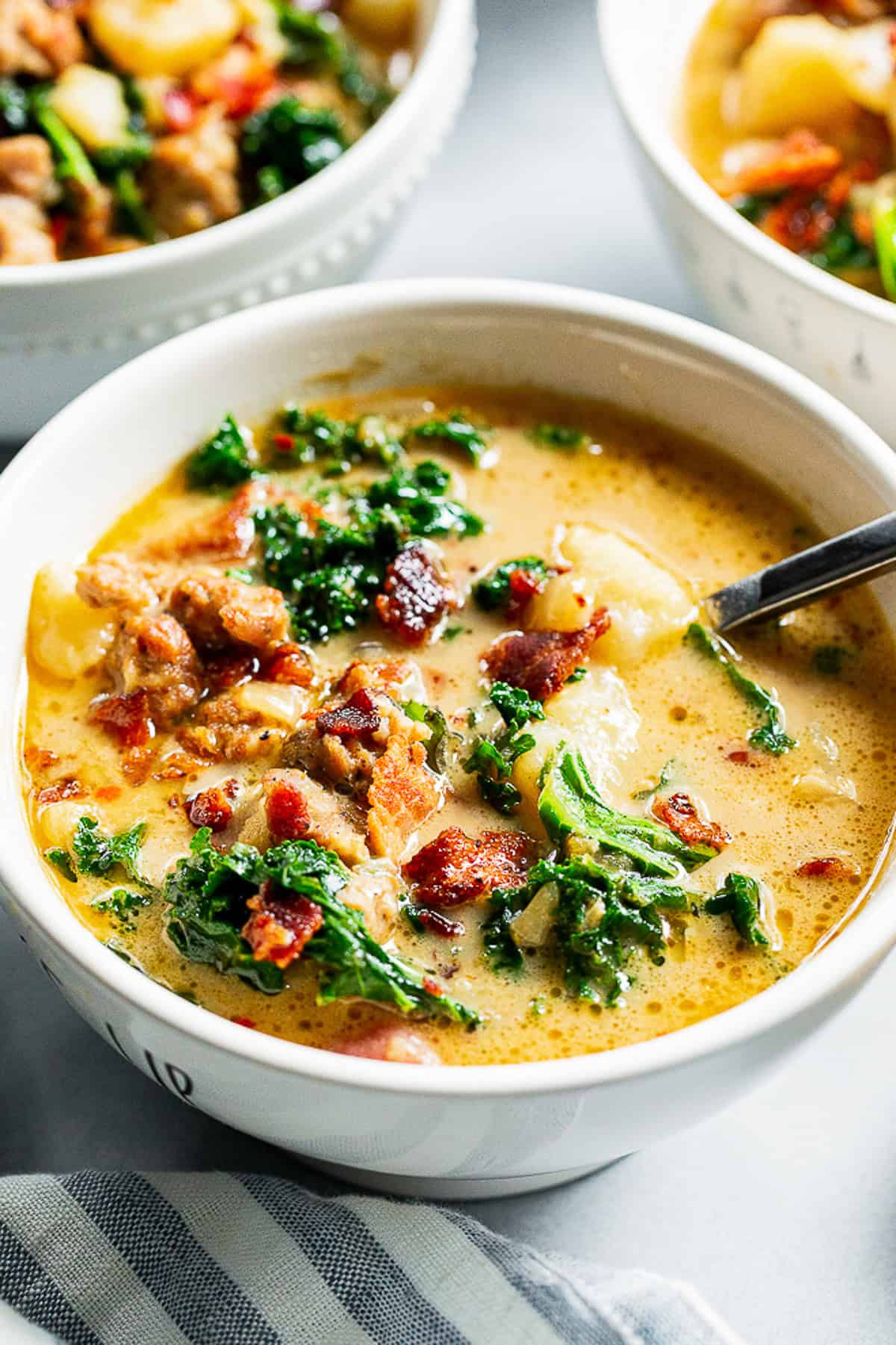 Healthy Zuppa Toscana with Italian sausage, potatoes, kale and crispy bacon in a creamy dairy-free broth