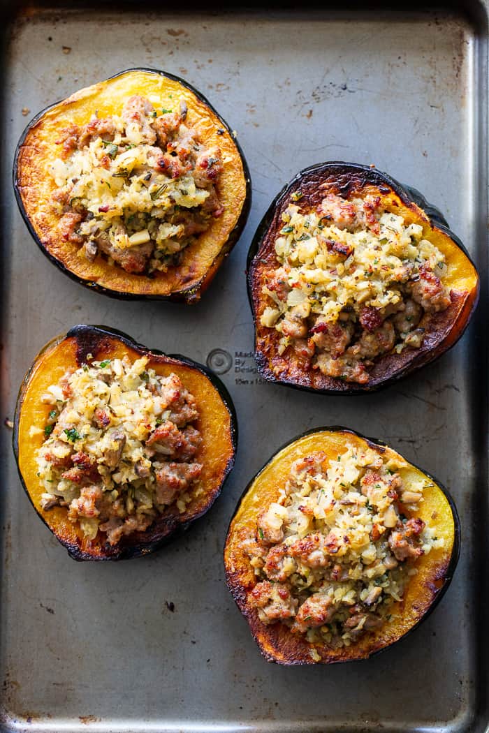 This savory stuffed acorn squash is so delicious it’s addicting!  A sausage and cauliflower rice stuffing is seasoned with lots of fresh herbs and served toasty in roasted acorn squash bowls.  Perfect as a holiday side dish or an anytime meal.  Paleo, Whole30, and low in carbs.