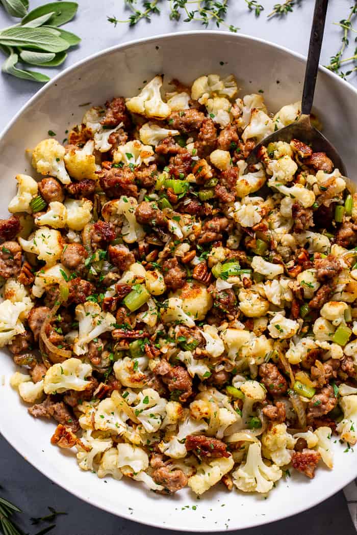 This cauliflower stuffing is packed with goodies like crispy browned sausage, caramelized onions, toasty pecans and savory herbs.  It’s low carb, Whole30 compliant and keto friendly.  It’s sure to be a total showstopper at your holiday table, even for the non-paleo crowd!