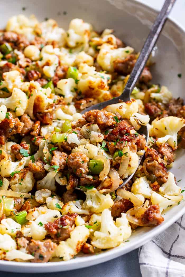 This cauliflower stuffing is packed with goodies like crispy browned sausage, caramelized onions, toasty pecans and savory herbs.  It’s low carb, Whole30 compliant and keto friendly.  It’s sure to be a total showstopper at your holiday table, even for the non-paleo crowd!
