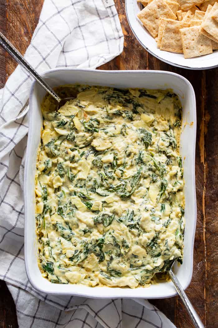 This creamy spinach artichoke dip is packed with cheesy flavor without using any dairy at all!  A cashew based cream sauce is mixed with a savory spinach artichoke mixture and baked to perfection.  Paleo, vegan, dairy-free, egg-free, and Whole30 compliant.