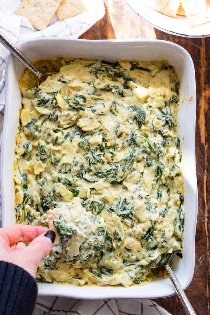 This creamy spinach artichoke dip is packed with cheesy flavor without using any dairy at all!  A cashew based cream sauce is mixed with a savory spinach artichoke mixture and baked to perfection.  Paleo, vegan, dairy-free, egg-free, and Whole30 compliant.