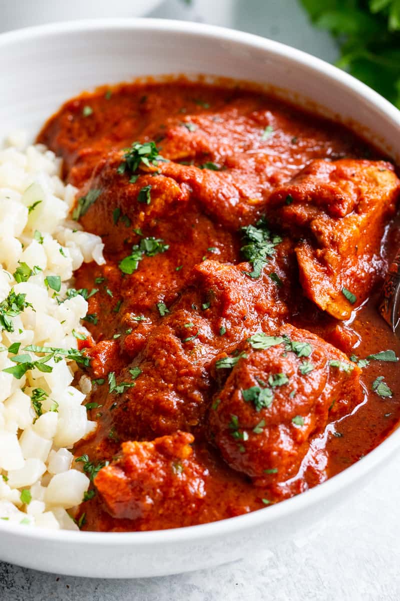 This Instant Pot Indian Butter Chicken is super easy to make and so flavorful!  With just the right amount of spice and a thick creamy tomato sauce, It’s perfect over cauliflower rice to keep it Paleo, Whole30, and keto friendly. #cleaneating #whole30 #paleo #keto