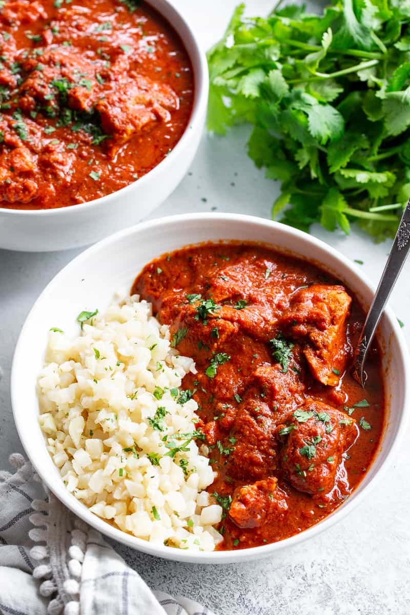 This Instant Pot Indian Butter Chicken is super easy to make and so flavorful!  With just the right amount of spice and a thick creamy tomato sauce, It’s perfect over cauliflower rice to keep it Paleo, Whole30, and keto friendly. #cleaneating #whole30 #paleo #keto