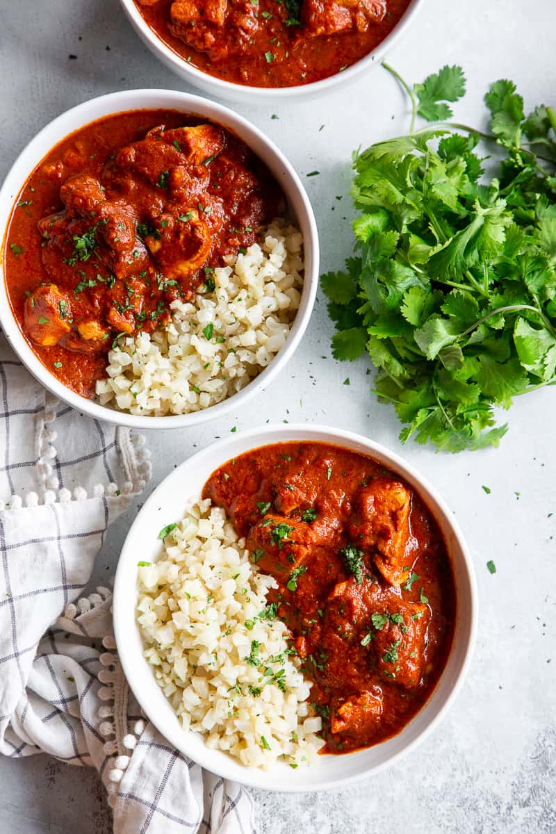 This Instant Pot Indian Butter Chicken is super easy to make and so flavorful!  With just the right amount of spice and a thick creamy tomato sauce, It’s perfect over cauliflower rice to keep it Paleo, Whole30, and keto friendly. #cleaneating #whole30 #paleo #keto