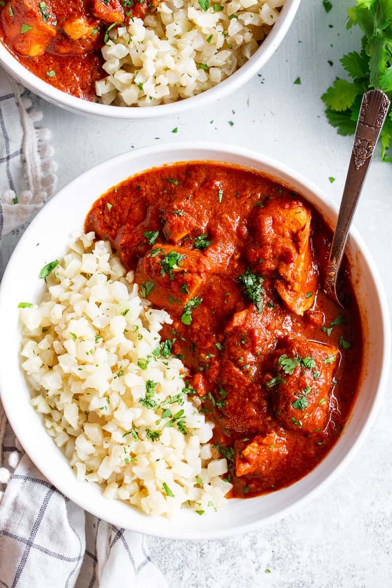 This Instant Pot Indian Butter Chicken is super easy to make and so flavorful!  With just the right amount of spice and a thick creamy tomato sauce, It’s perfect over cauliflower rice to keep it Paleo, Whole30, and keto friendly. #cleaneating #whole30 #paleo #keto