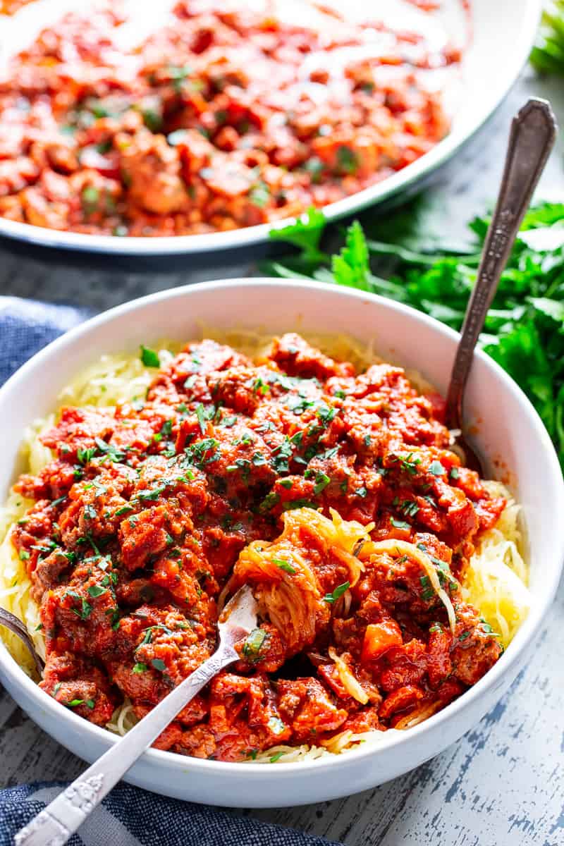 This easy spaghetti squash bolognese is great for healthy weeknight dinners with a flavorful meat sauce and perfectly roasted “al dente” spaghetti squash!  It’s dairy-free, Whole30 compliant, paleo, gluten free and Low FODMAP too. #paleo #cleaneating #gutfriendly #SIBO