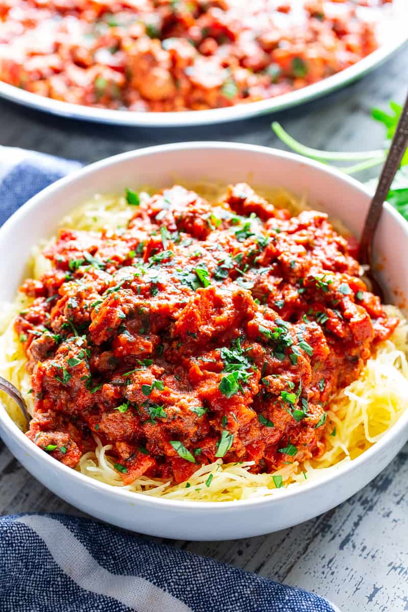 This easy spaghetti squash bolognese is great for healthy weeknight dinners with a flavorful meat sauce and perfectly roasted “al dente” spaghetti squash!  It’s dairy-free, Whole30 compliant, paleo, gluten free and Low FODMAP too. #paleo #cleaneating #gutfriendly #SIBO