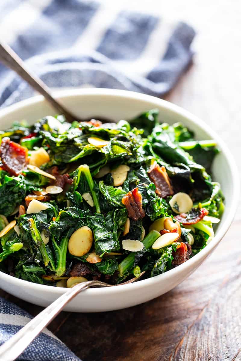 This delicious and simple sautéed kale with bacon and almonds is a savory healthy side dish that you’ll want on repeat!  It’s paleo and Whole30 friendly, keto, and Low FODMAP.  Serve it with any main course to add lots of flavor and nutrients to your meal. #keto #cleaneating #paleo #whole30 #lowfodmap