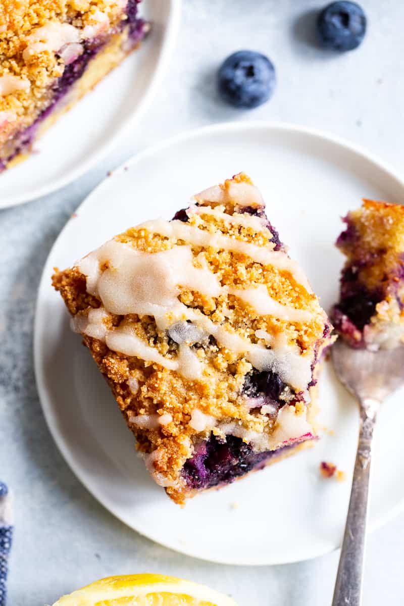 This Lemon Blueberry Coffee Cake is bursting with fresh lemon flavor and juicy blueberries!  It starts with a  perfectly moist lemon almond cake layer with fresh blueberries piled with crumb topping and drizzled with lemon glaze.  It’s gluten-free and paleo and will become a favorite dessert or breakfast treat with the first bite!  #cleaneating #paleo #kingarthurflour @kingarthurflour #AD