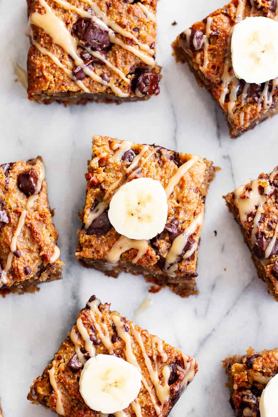 These one-bowl almond butter banana bread bars are a simple and totally delicious treat to make any time!  Great for snacks and dessert, they’re packed with good fats, banana flavor and dark chocolate.  Top them with an almond butter icing to take them to the next level!  Vegan, paleo, refined sugar free, egg free. #paleo #vegan #glutenfree