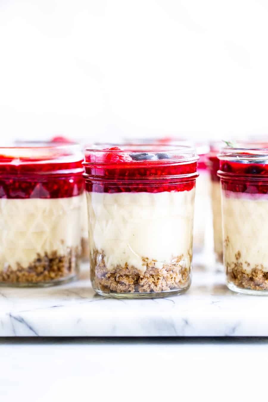 These fun single serve no bake cheesecake jars are made with real food ingredients and are completely dairy and soy free!  They’re perfect to make ahead of time for an easy and delicious healthy dessert you can grab anytime.  Kid friendly, paleo, vegan, and easy to make. #vegan #paleo #cheesecake #healthydessert