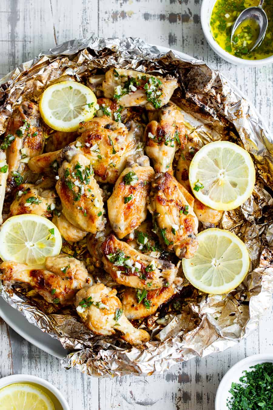 These delicious, grilled chicken wings have an easy sauce with lots of bright lemon, savory garlic, and fresh herbs and go perfectly with all your favorite potato salads and summer sides!  These flavor-packed wings are Whole30 compliant, paleo, keto, and dairy-free.  