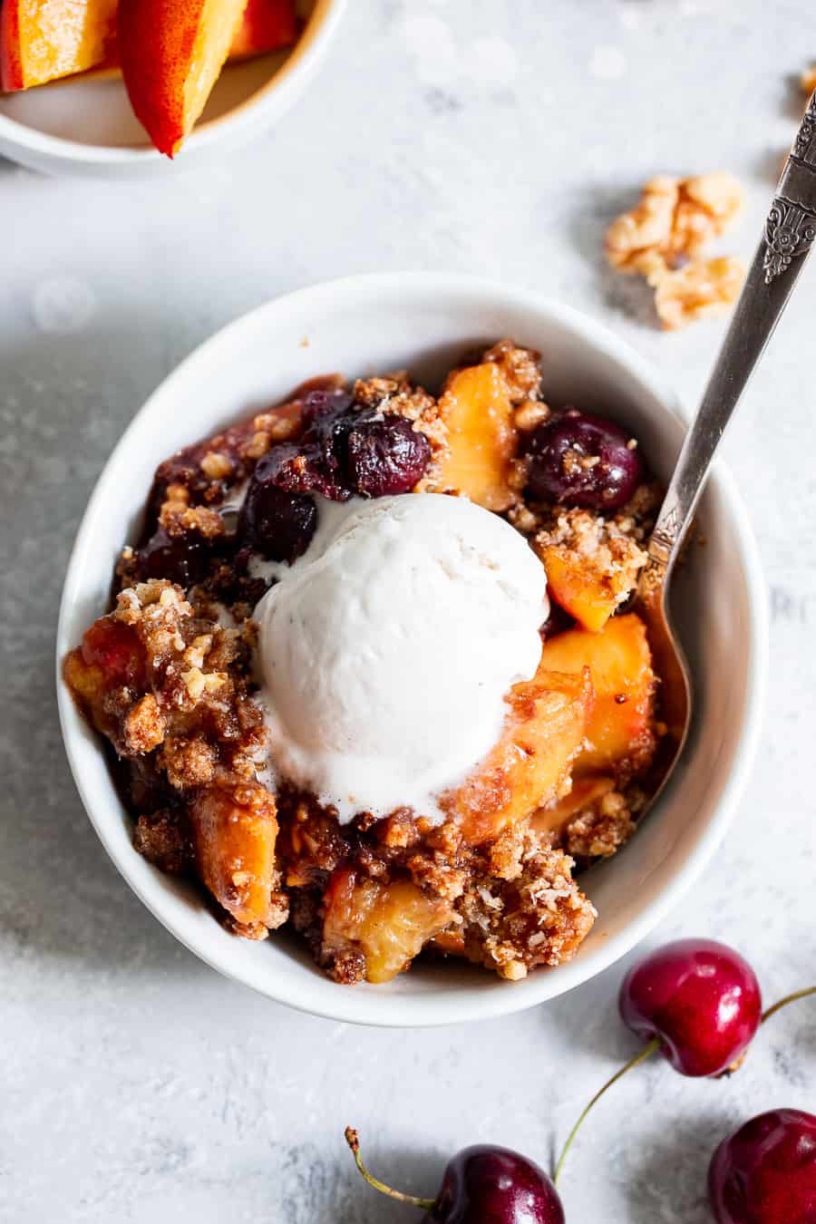 This cherry and peach crisp is irresistibly delicious and easy to make!  A sweet gooey peach and cherry filling is topped with a toasty crumble for a summer dessert that will make everyone come back for seconds.  It’s paleo, vegan, gluten-free, dairy-free and refined sugar free. #vegan #paleo #cleaneating #paleodessert