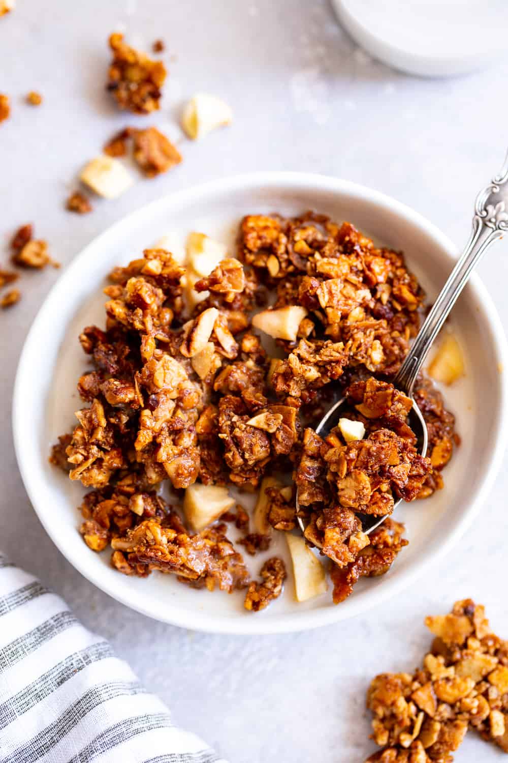 This apple cinnamon granola is the ultimate grain free granola for fall! Packed with apple pie spice, chopped nuts, coconut, chewy dried apples and sweetened with maple syrup, this baked granola is perfect for breakfast with dairy free milk or for snacking on by the handful! It’s vegan, dairy free, and paleo friendly. #paleo #vegan #cleaneating