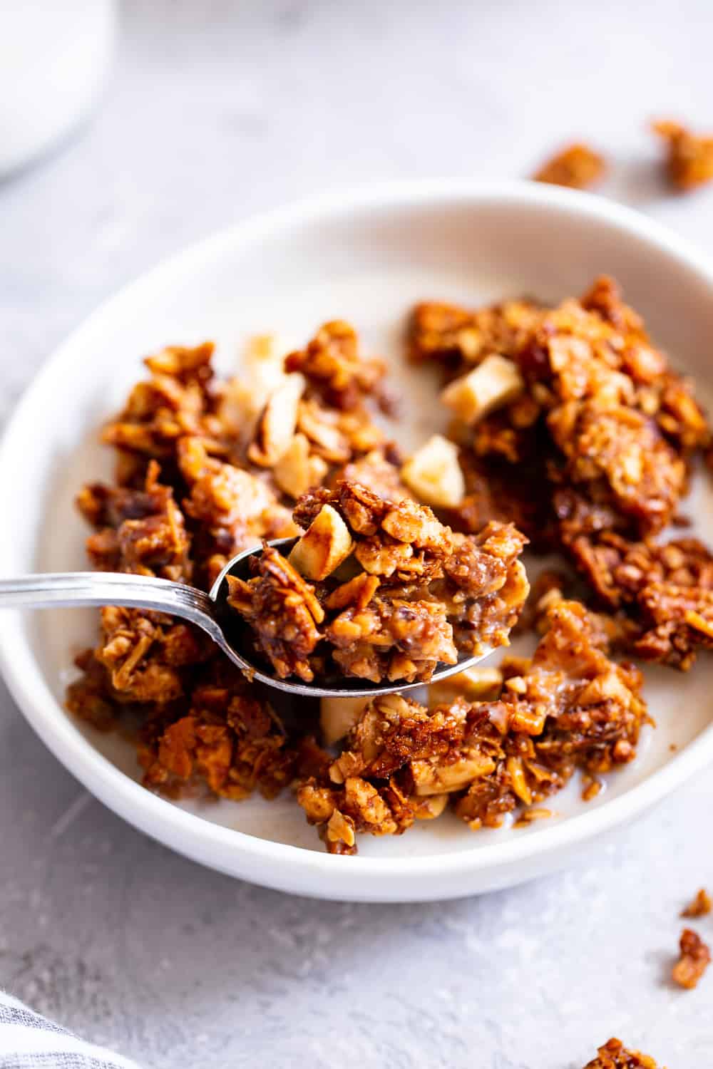 This apple cinnamon granola is the ultimate grain free granola for fall! Packed with apple pie spice, chopped nuts, coconut, chewy dried apples and sweetened with maple syrup, this baked granola is perfect for breakfast with dairy free milk or for snacking on by the handful! It’s vegan, dairy free, and paleo friendly. #paleo #vegan #cleaneating