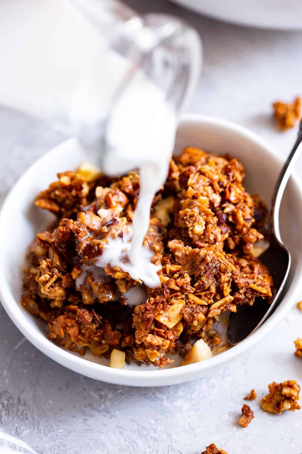 This apple cinnamon granola is the ultimate grain free granola for fall! Packed with apple pie spice, chopped nuts, coconut, chewy dried apples and sweetened with maple syrup, this baked granola is perfect for breakfast with dairy free milk or for snacking on by the handful! It’s vegan, dairy free, and paleo friendly. #paleo #vegan #cleaneating