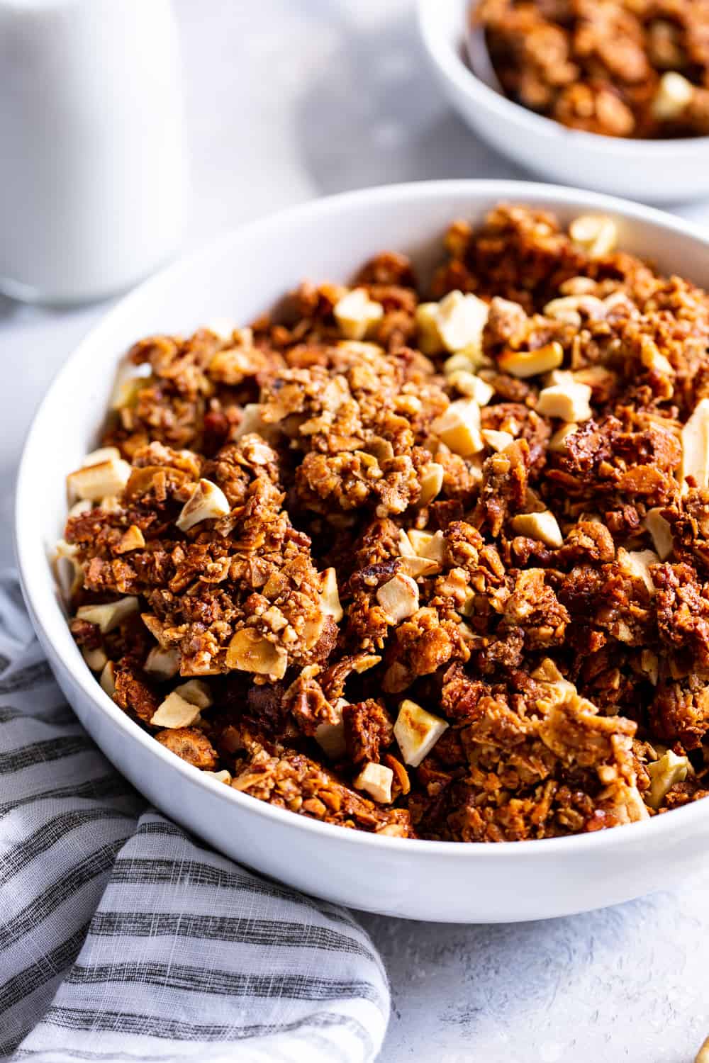 This apple cinnamon granola is the ultimate grain free granola for fall! Packed with apple pie spice, chopped nuts, coconut, chewy dried apples and sweetened with maple syrup, this baked granola is perfect for breakfast with dairy free milk or for snacking on by the handful! It’s vegan, dairy free, and paleo friendly. #paleo #vegan #cleaneating