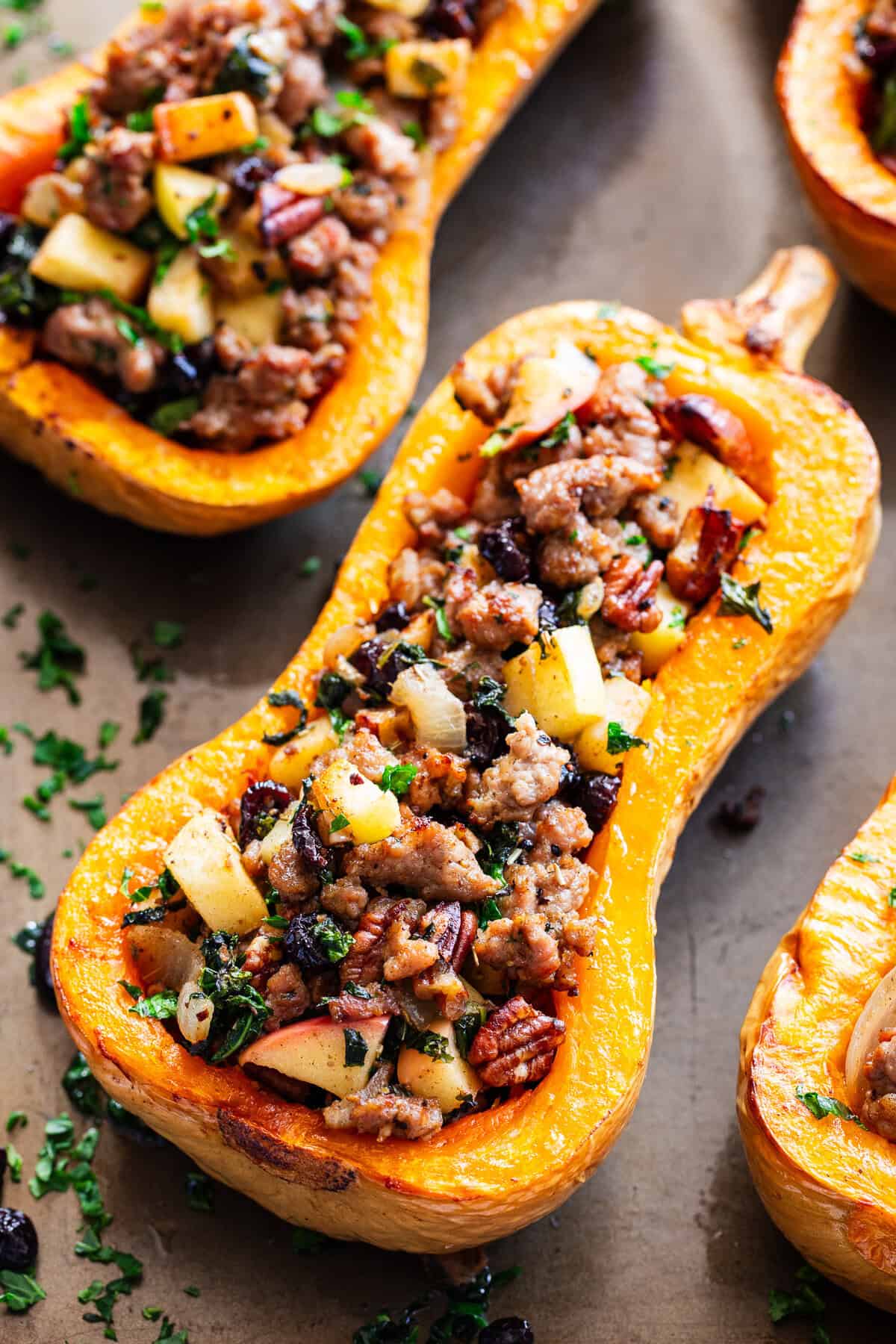 Roasted stuffed butternut squash is filled with a savory-sweet mixture of Italian sausage, apples, cranberries, kale, pecans and fresh herbs.