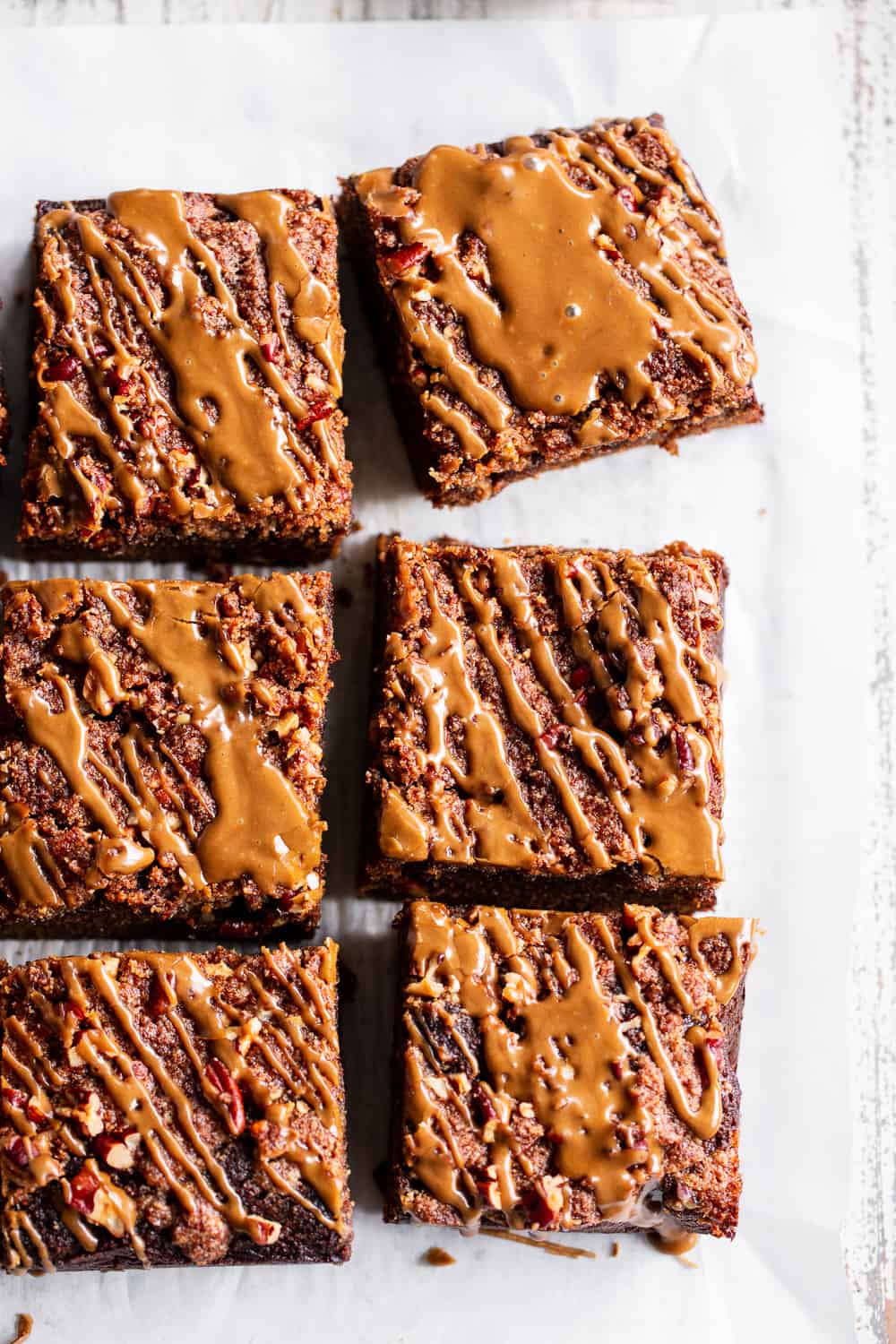 This Paleo Pumpkin Gingerbread Coffee Cake has it all!  Moist cake with sweet warm pumpkin spices and molasses topped with an addicting crumb topping and gingerbread icing!  Fancy enough to serve to guests but so delicious that you’ll want to have some to snack on all season long.