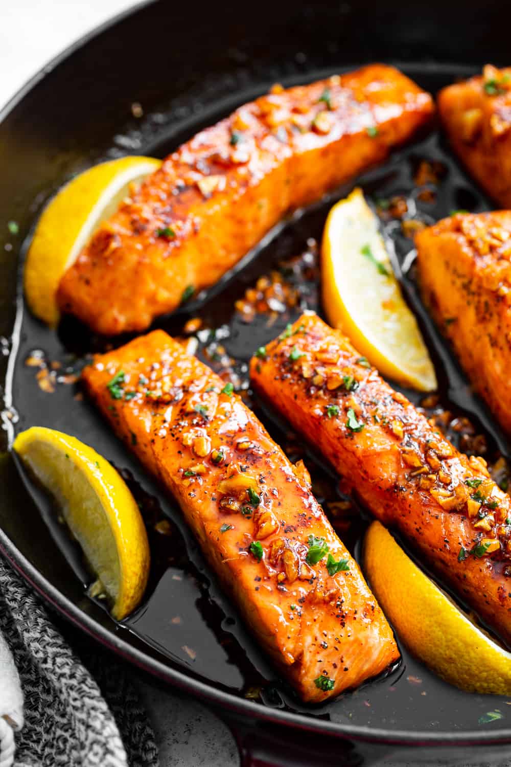 This simple 20 minute honey garlic salmon is made in one skillet and the sauce is addicting!  It’s paleo, gluten free and a family favorite.  Serve it over cauliflower rice and with your favorite veggies for a healthy weeknight meal.  #paleo #cleaneating #salmon