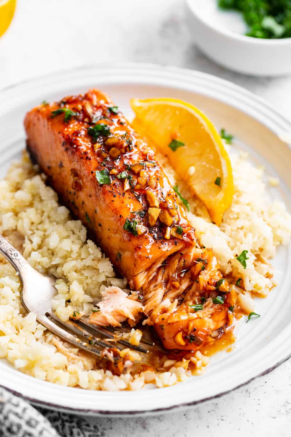 This simple 20 minute honey garlic salmon is made in one skillet and the sauce is addicting!  It’s paleo, gluten free and a family favorite.  Serve it over cauliflower rice and with your favorite veggies for a healthy weeknight meal.  #paleo #cleaneating #salmon