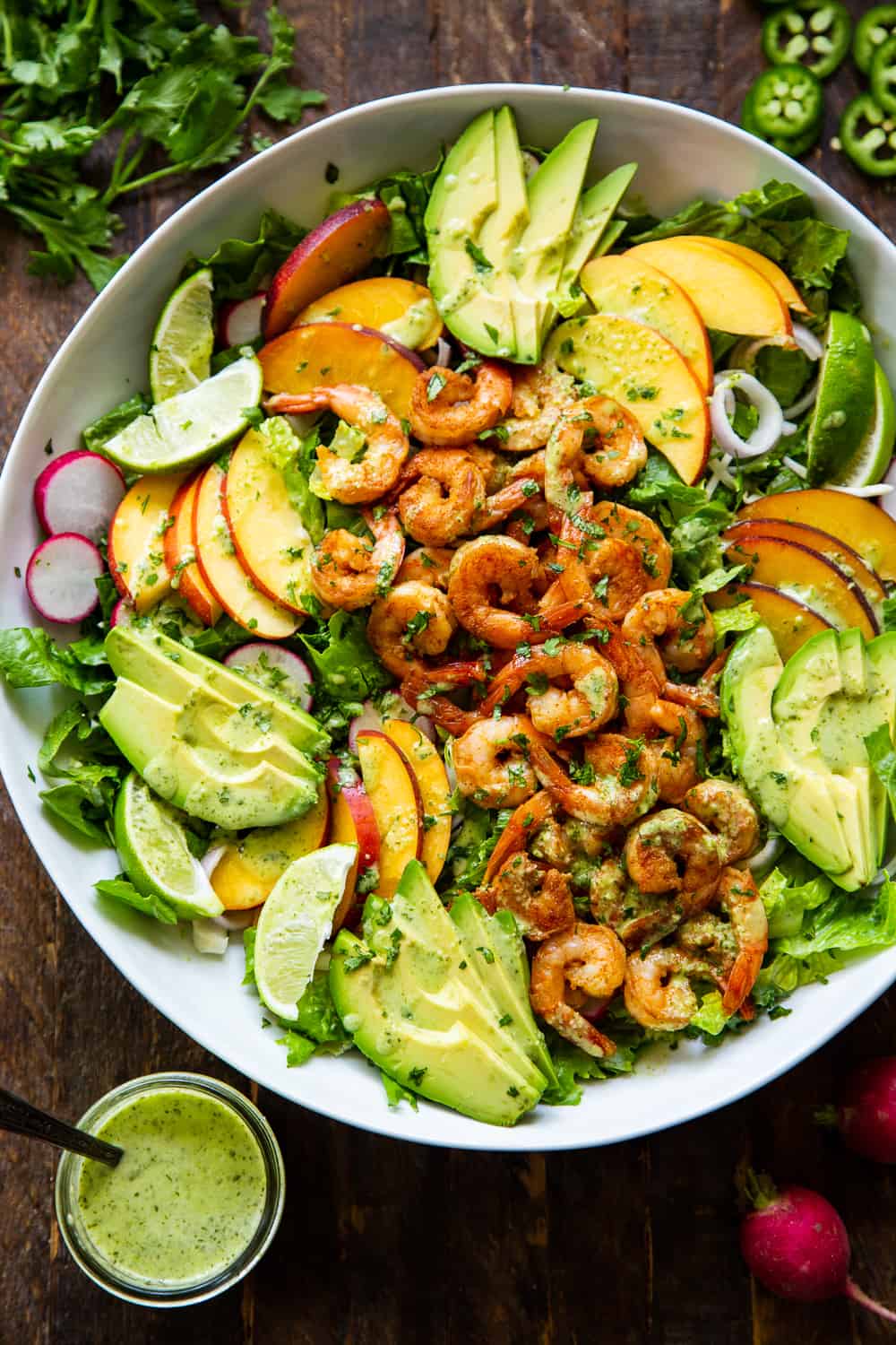 This healthy salad has tons of savory and sweet flavors plus spice! Spicy chipotle shrimp over a fresh summer salad with the most delicious cilantro dressing! Serve it for lunch or dinner over the summer or for your next BBQ. It’s easy to throw together and paleo friendly with a Whole30 option. #paleo #cleaneating #shrimp #whole30