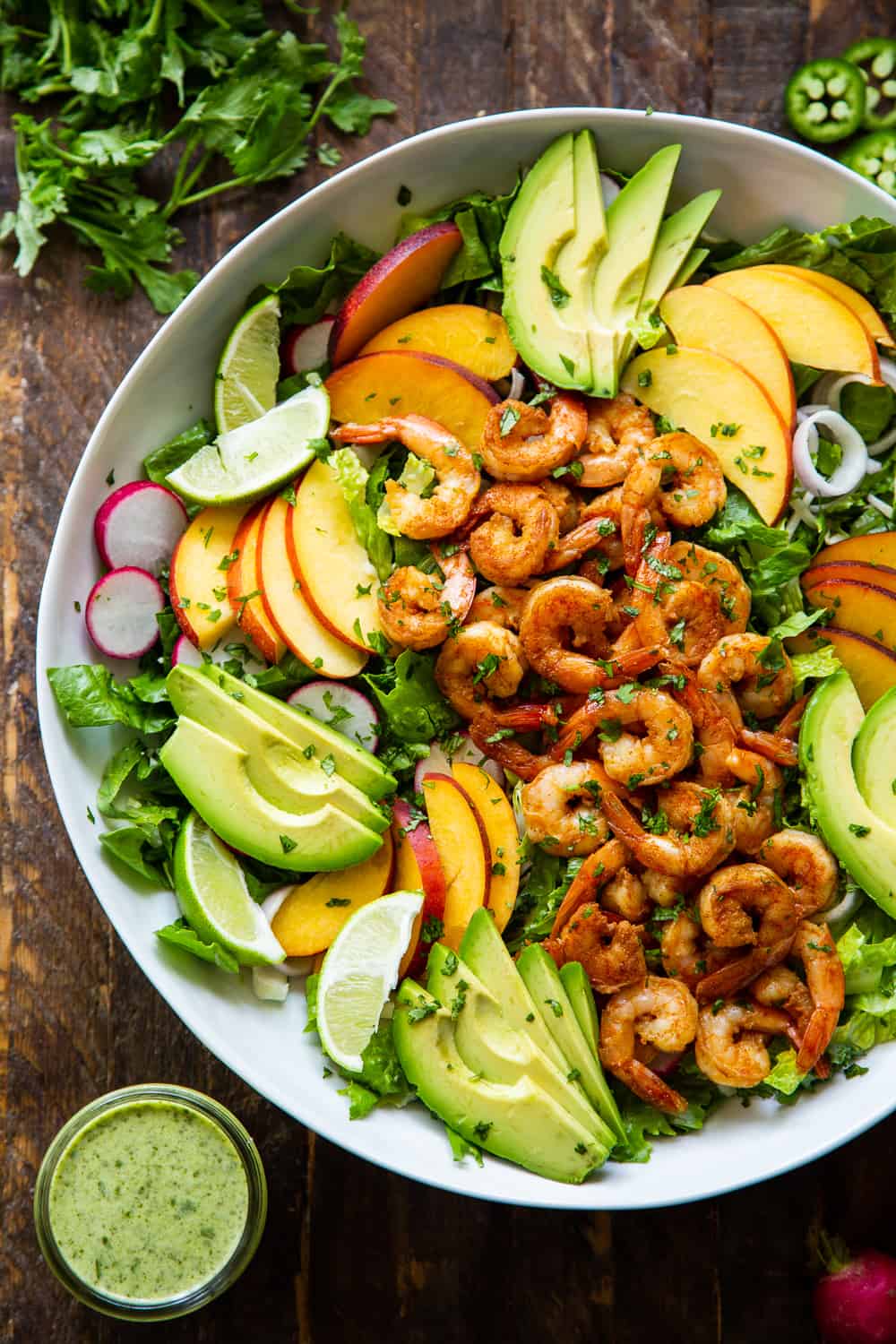 This healthy salad has tons of savory and sweet flavors plus spice! Spicy chipotle shrimp over a fresh summer salad with the most delicious cilantro dressing! Serve it for lunch or dinner over the summer or for your next BBQ. It’s easy to throw together and paleo friendly with a Whole30 option. #paleo #cleaneating #shrimp #whole30