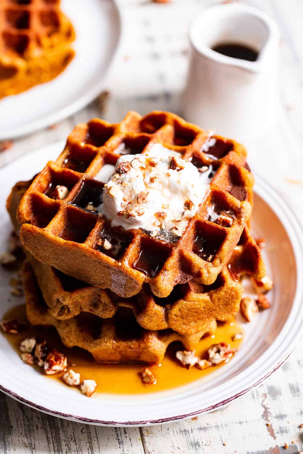 These Paleo Pumpkin Waffles are crisp on the outside, soft inside and filled with warm fall spices. They’re just sweet enough to enjoy alone or you can top with all your favorites like maple syrup, coconut whipped cream and chopped pecans. They’re kid approved and freeze well so you can enjoy one on the go! Gluten free, dairy free. #paleo #pumpkin #cleaneating #waffles #glutenfree