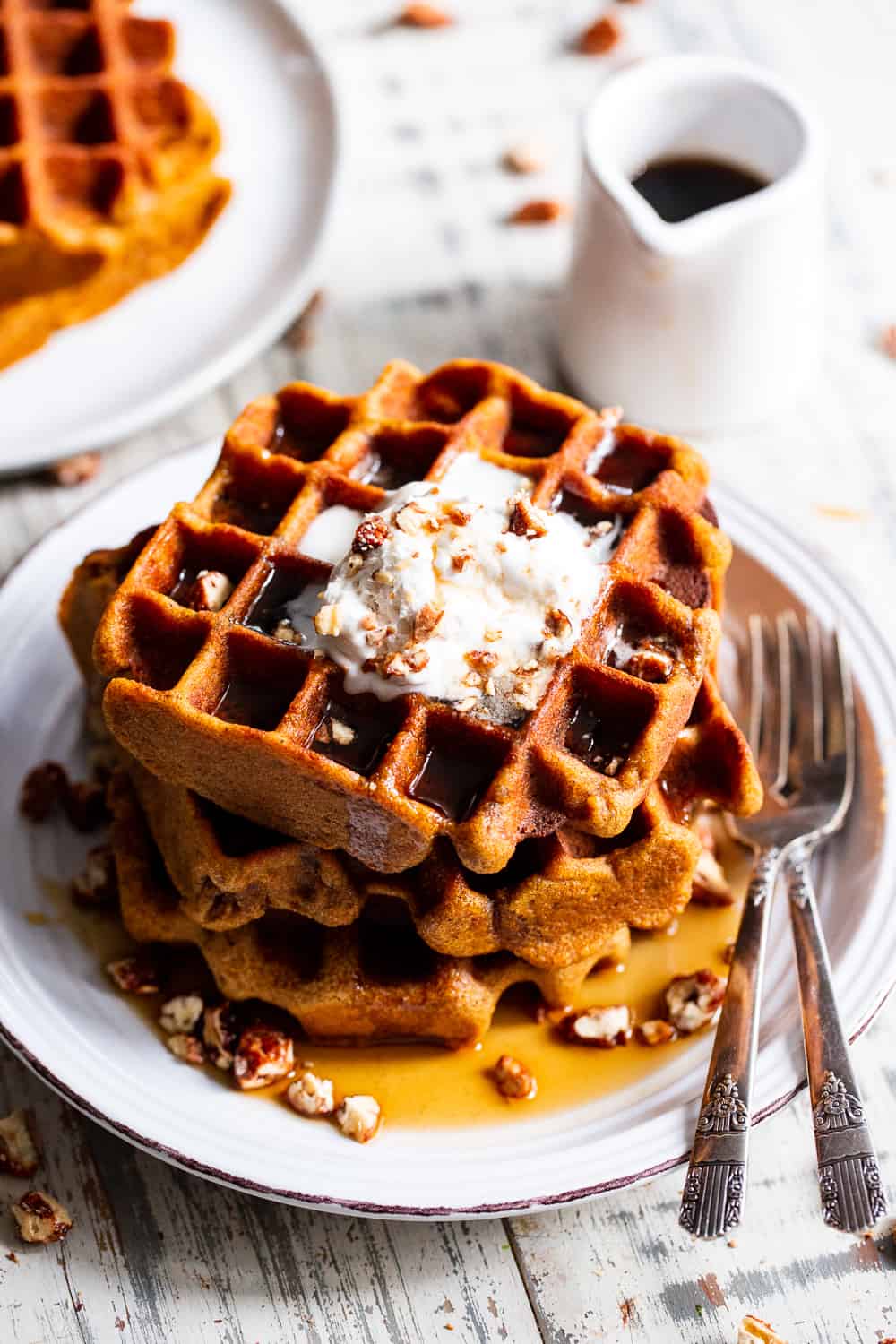 These Paleo Pumpkin Waffles are crisp on the outside, soft inside and filled with warm fall spices. They’re just sweet enough to enjoy alone or you can top with all your favorites like maple syrup, coconut whipped cream and chopped pecans. They’re kid approved and freeze well so you can enjoy one on the go! Gluten free, dairy free. #paleo #pumpkin #cleaneating #waffles #glutenfree