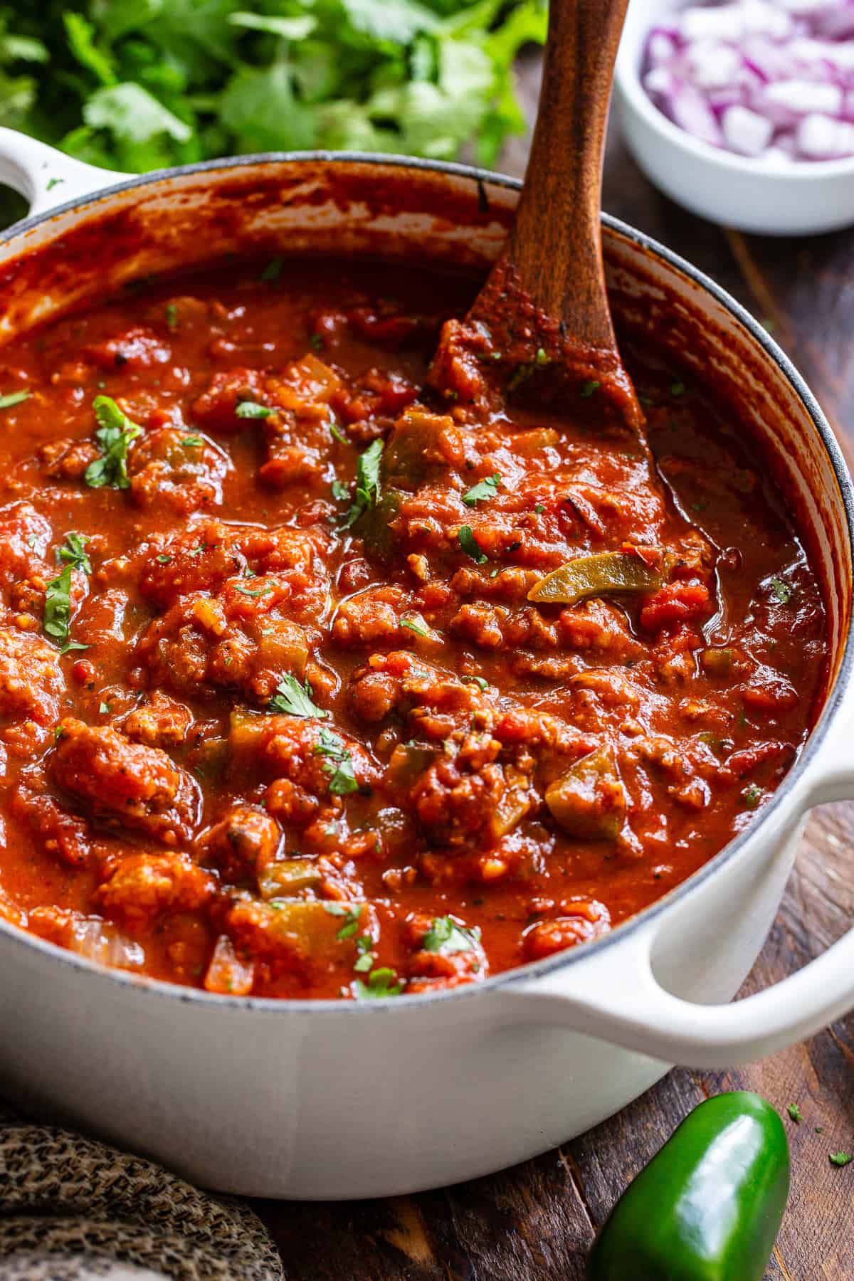 One-pot pumpkin chili with ground meat, tomatoes and peppers in a Dutch oven