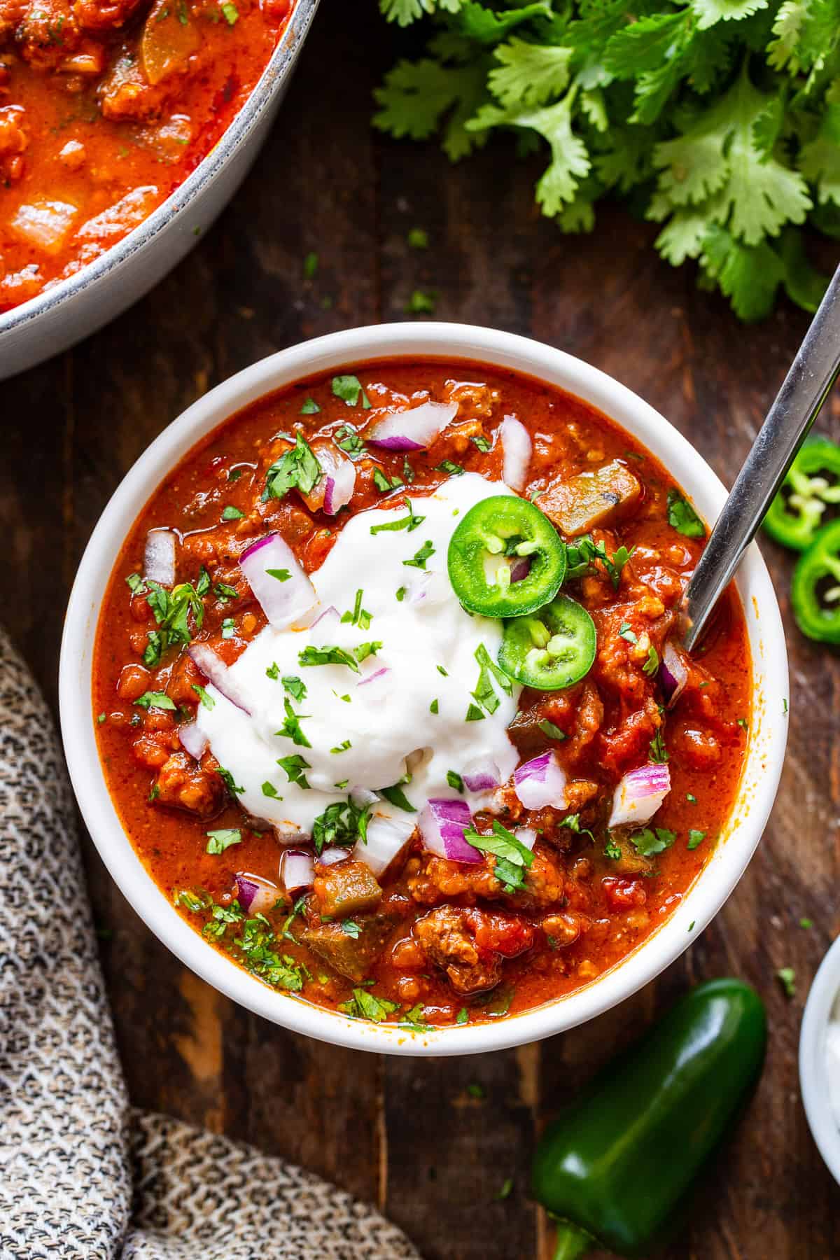 Easy pumpkin chili topped with dairy-free sour cream, jalapeños, red onion and cilantro