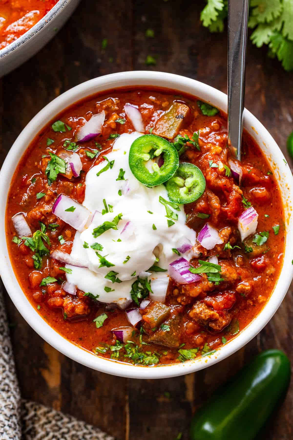 Easy pumpkin chili topped with dairy-free sour cream, jalapeños, red onion and cilantro
