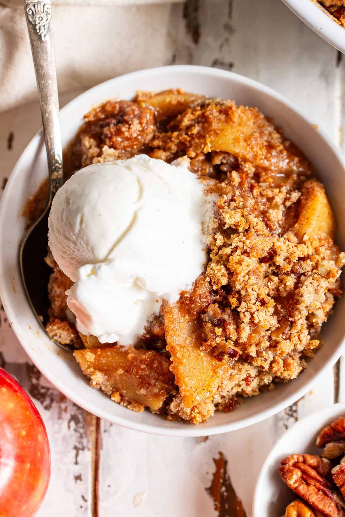 Close-up of apple crisp with tender cinnamon apples, pecan crumble and vanilla ice cream