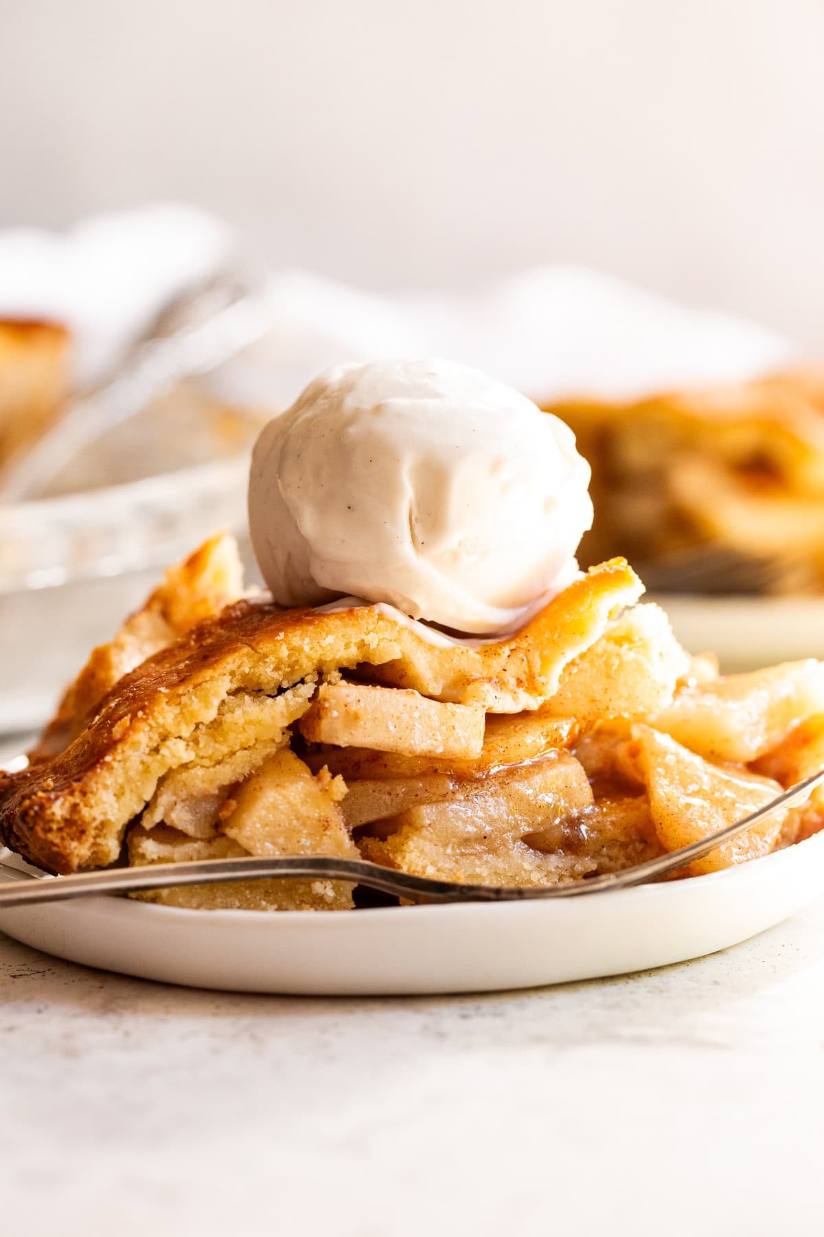 slice of paleo apple pie with vanilla ice cream on top