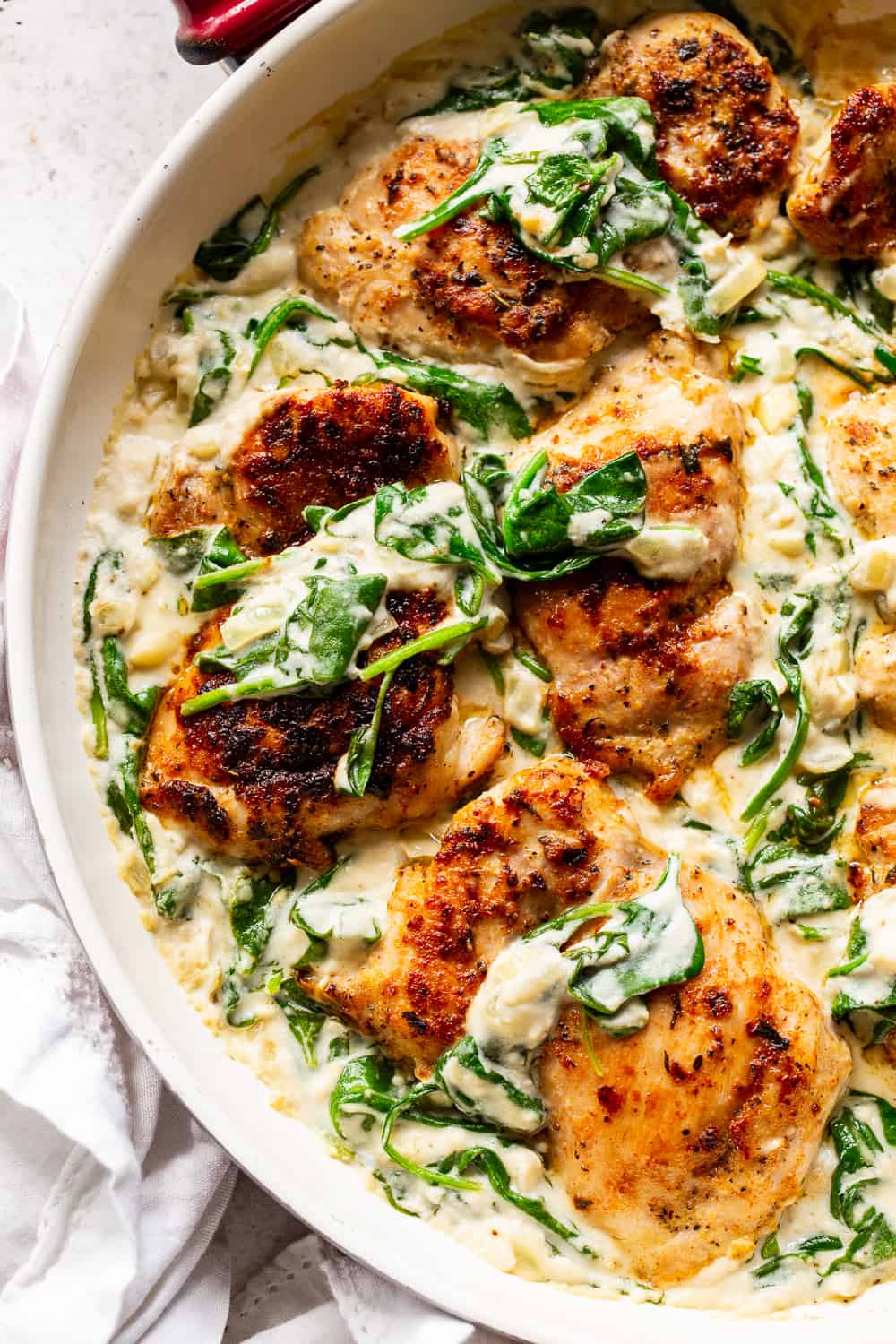 This one pot creamed spinach chicken is paleo, Whole30 friendly and dairy free but you’d never guess! Juicy seasoned chicken is cooked in one skillet with a creamy, “cheesy” sauce and spinach that’s easy and great for weeknights! The leftovers are perfect for lunch the next day too. #paleo #whole30 #keto #cleaneating 