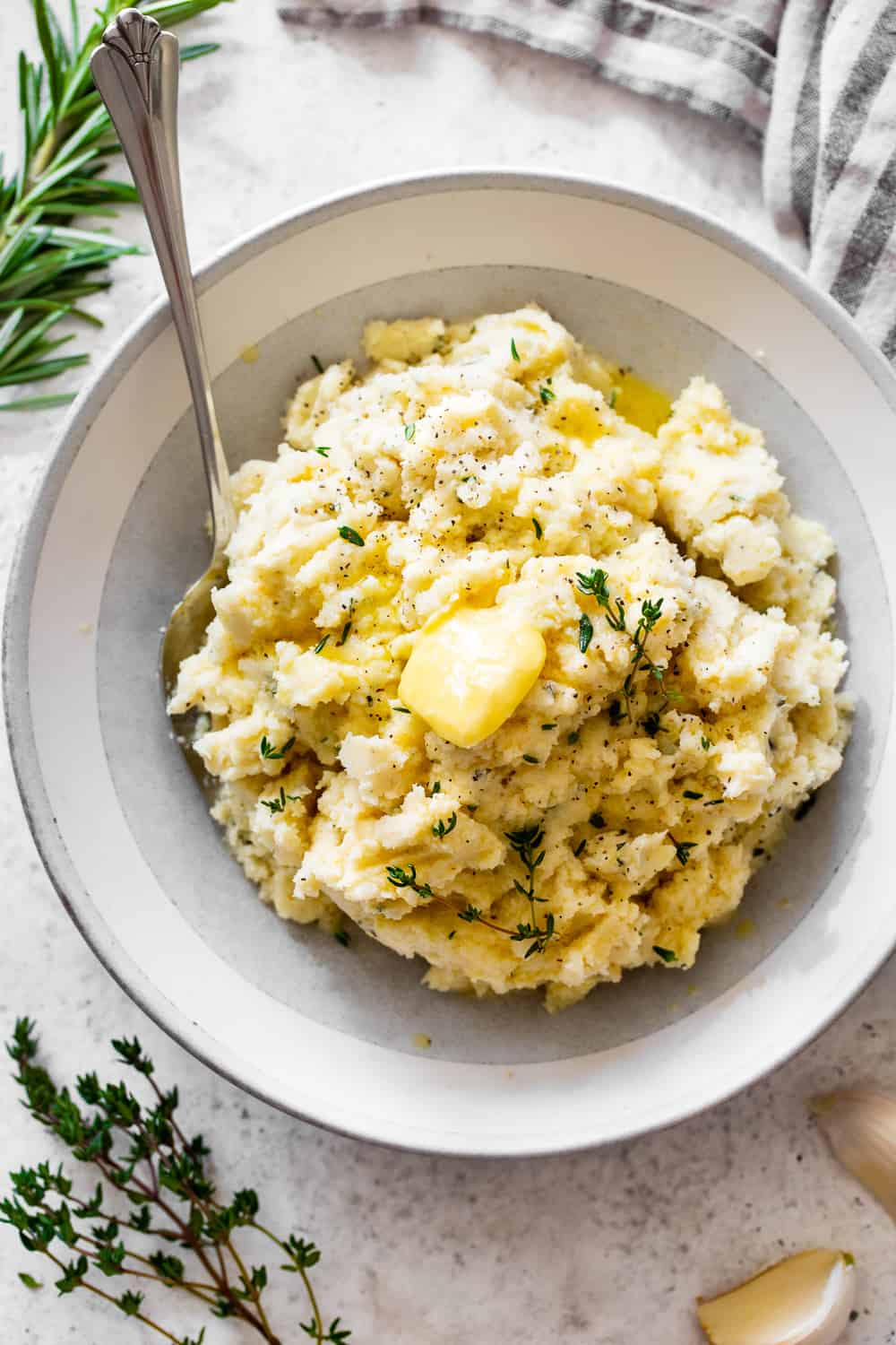 This is the simplest and most delicious recipe for mashed cauliflower (or cauliflower mashed potatoes!) Whether for a holiday dinner or anytime meal, this mashed cauliflower is super flavorful with savory garlic and fresh herbs, a side dish that will complement any main course and even steal the show! Paleo, Whole30, Keto and vegan option. #paleo #whole30 #keto #cleaneating 