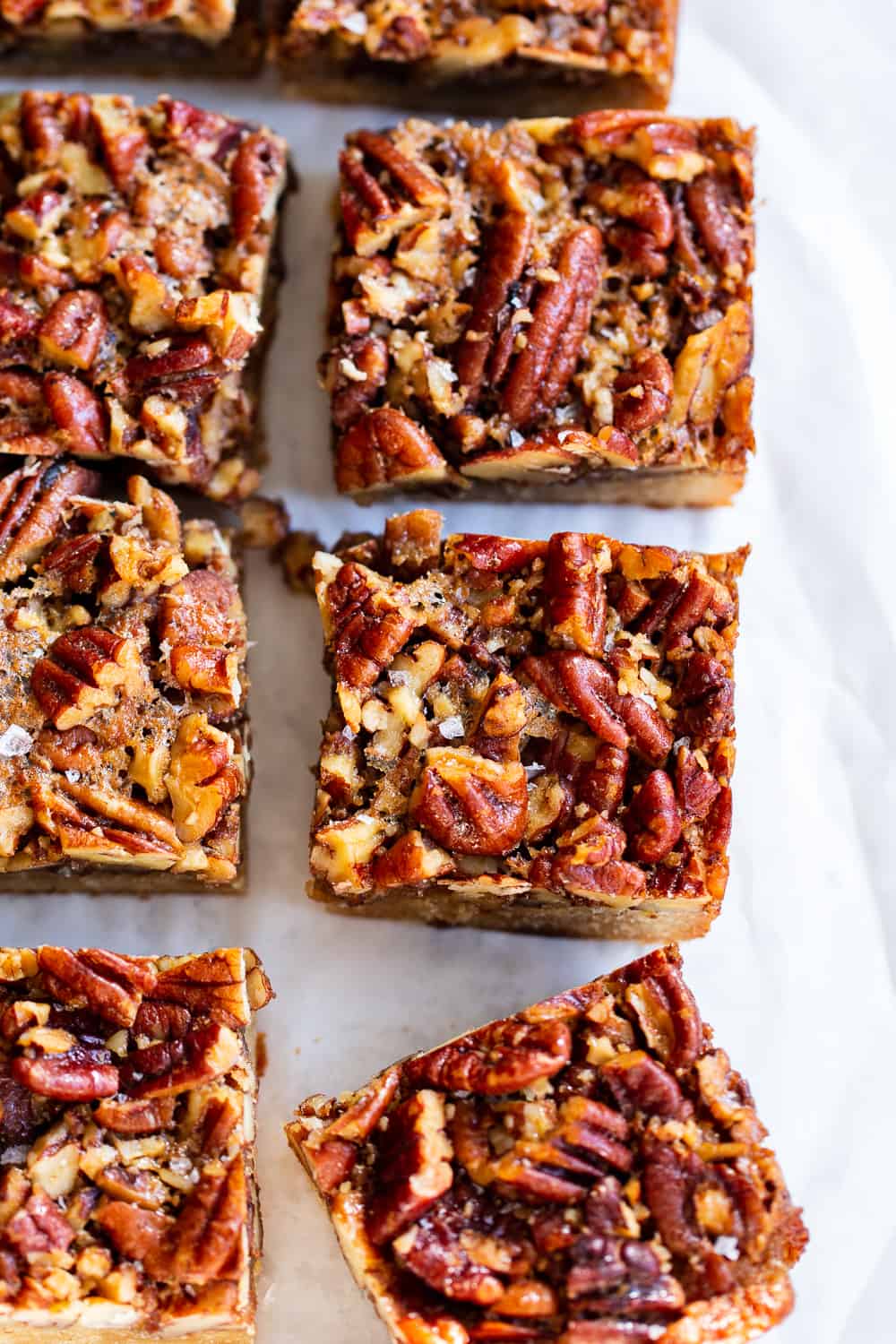 These pecan pie bars start with a sugar cookie crust, topped with a sweet, gooey caramelized pecan layer. No refined sugar, gluten free, grain free, and dairy free options. Great for holiday desserts or an anytime special treat! #paleo #glutenfree #pecanpie #paleobaking #thanksgiving #christmas