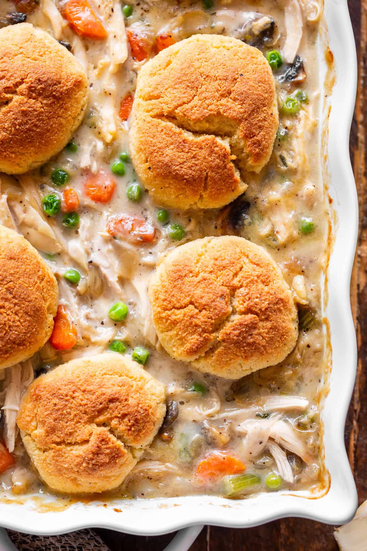 chicken pot pie casserole with golden biscuits and creamy chicken vegetable filling.