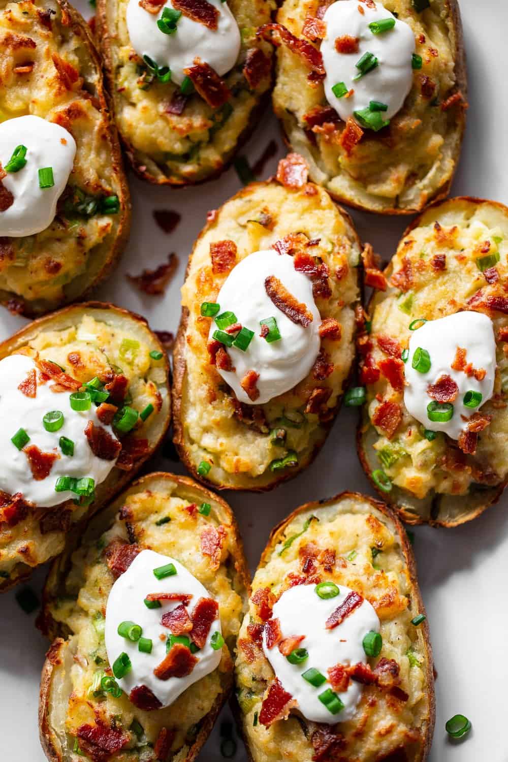 It’s all the delicious comfort of classic twice baked potatoes, made Whole30 friendly! Potato skins are loaded with a creamy mixture of mashed potatoes, bacon, scallions and even a dairy free sour cream. Great as a side dish or full meal, perfect to prep ahead of time too and easy to reheat! #paleo #whole30 #cleaneating 