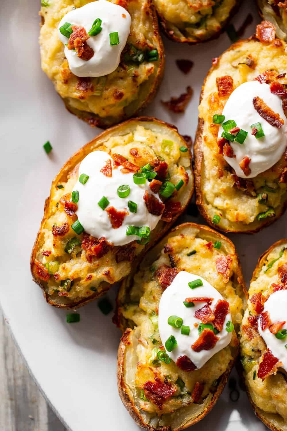 It’s all the delicious comfort of classic twice baked potatoes, made Whole30 friendly! Potato skins are loaded with a creamy mixture of mashed potatoes, bacon, scallions and even a dairy free sour cream. Great as a side dish or full meal, perfect to prep ahead of time too and easy to reheat! #paleo #whole30 #cleaneating 