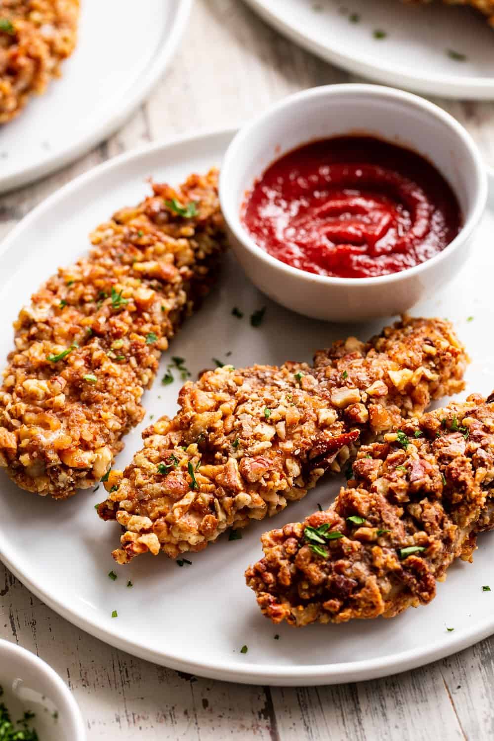 These pecan crusted chicken tenders are easy to throw together, baked in the oven and so tasty! Amazing with all your favorite dips and totally kid friendly, they're also paleo, Whole30 and keto friendly. #paleo #keto #cleaneating #chicken #whole30