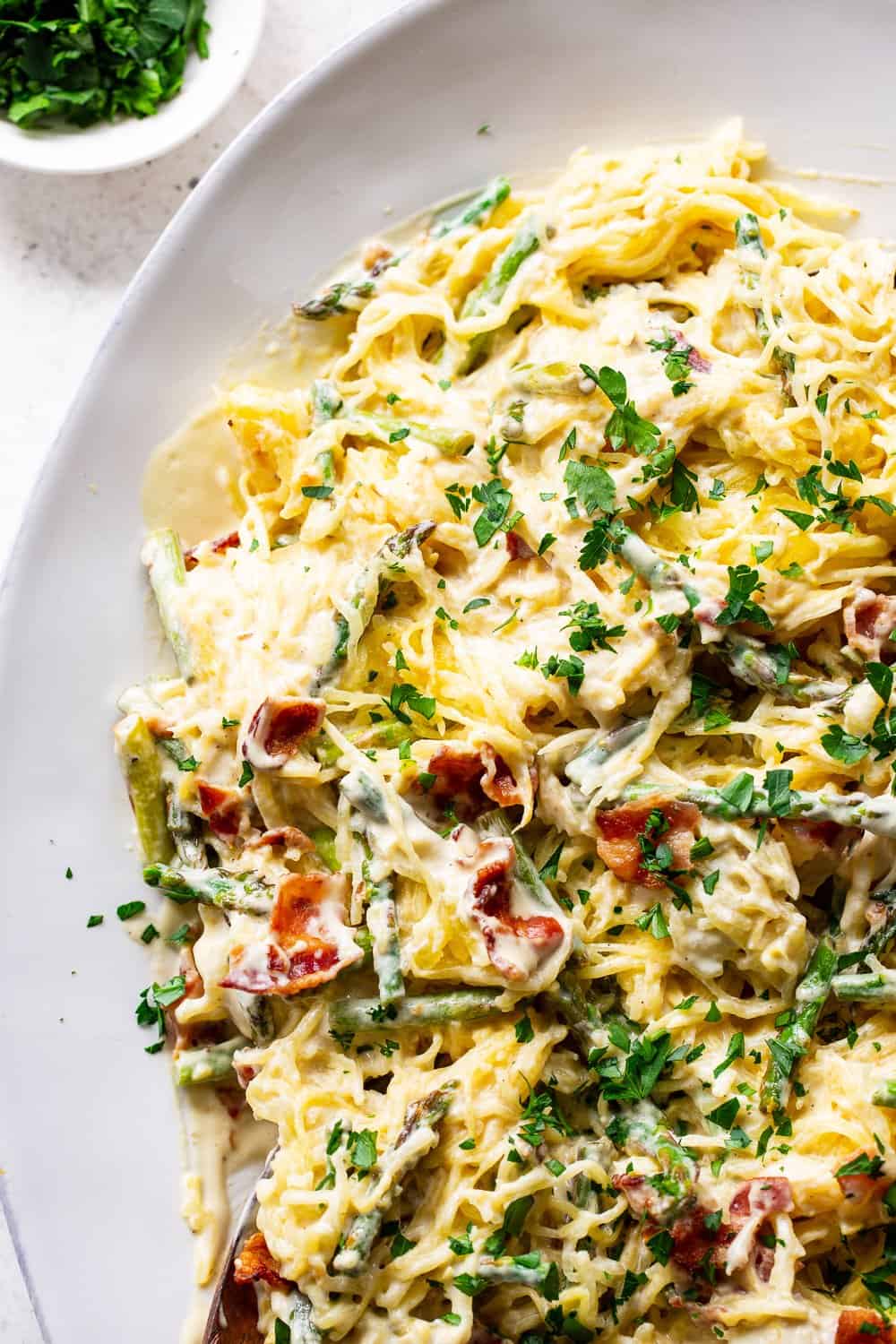 This roasted garlic spaghetti squash has a creamy savory sauce with crispy bacon plus sautéed asparagus. It’s flavor packed, low in carbs, paleo and Whole30 friendly. #paleo #whole30 #keto #lowcarb #cleaneating